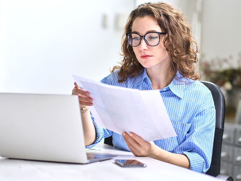 young woman accountant reviewing docs in her hand