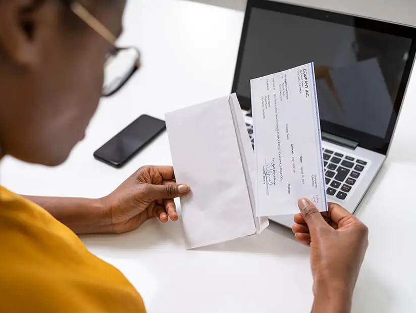 woman putting check in envelope