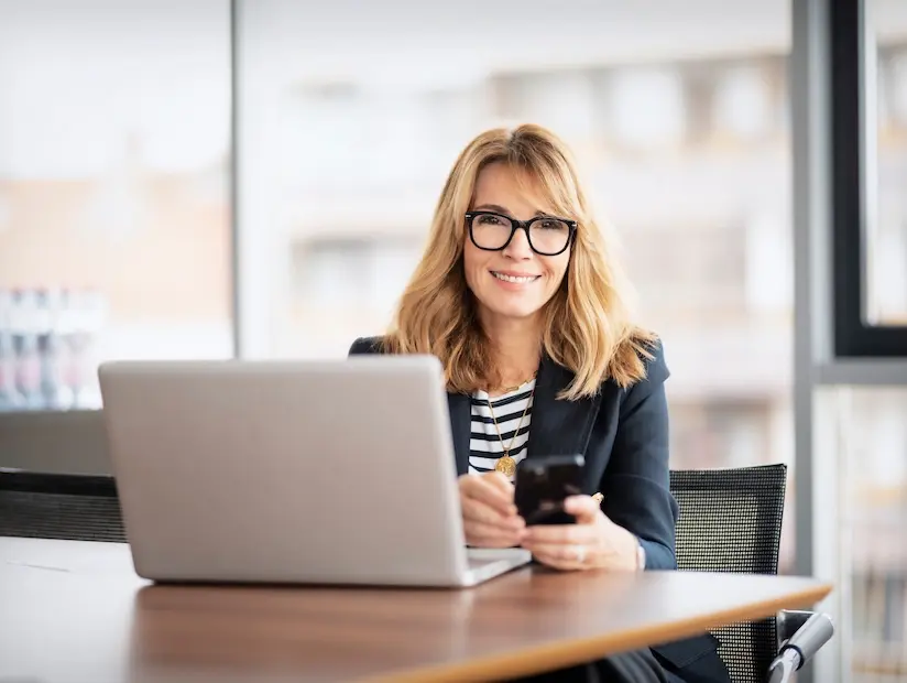 fractional-cfo-for-startups.webp Professional CFO smiles while working at her laptop