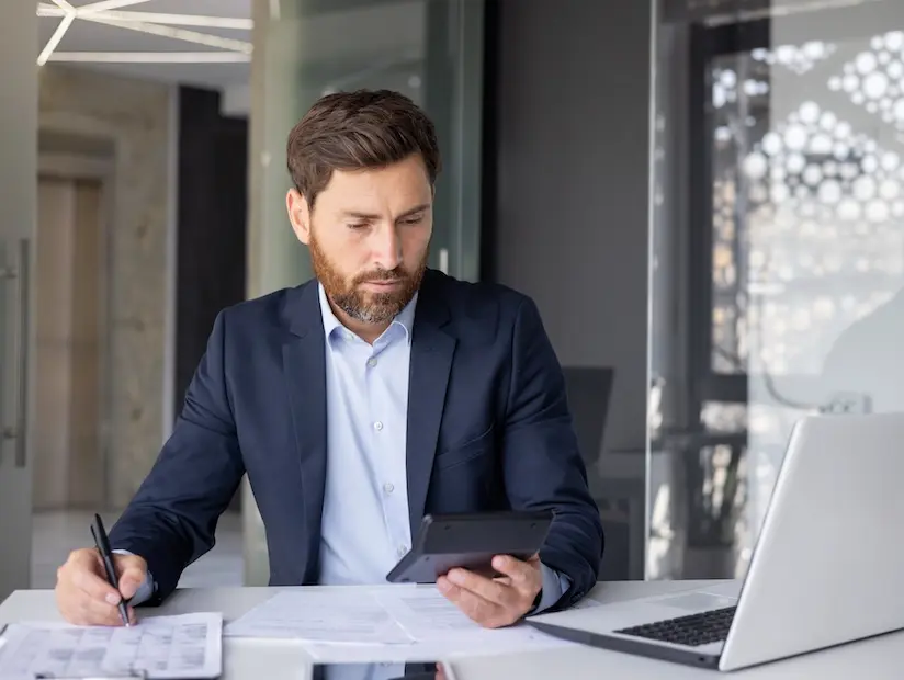tax-compliance-outsourcing-for-business-startups.webp Tax accountant works on calculator