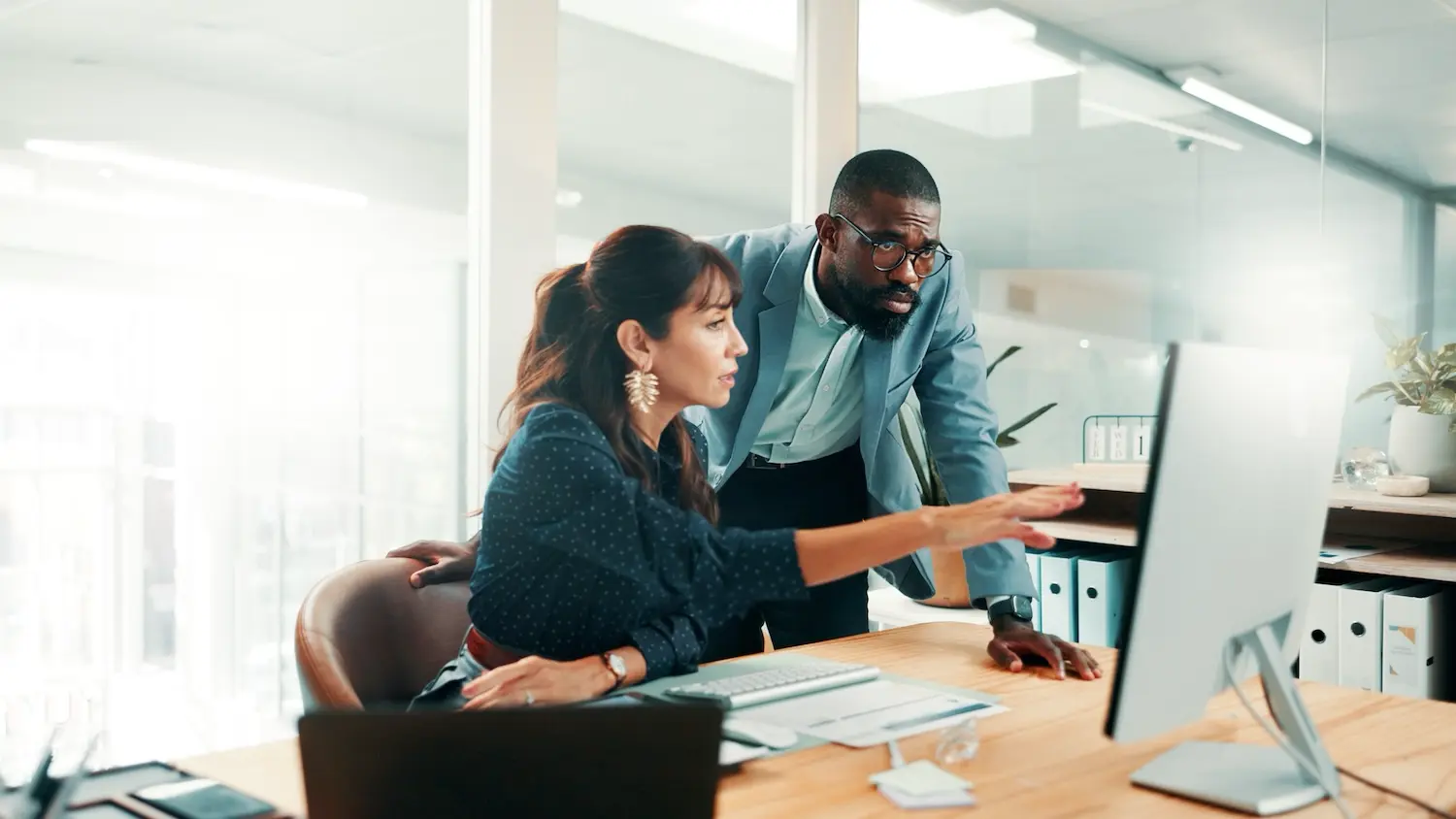 Two finance team members review and discuss a financial report.